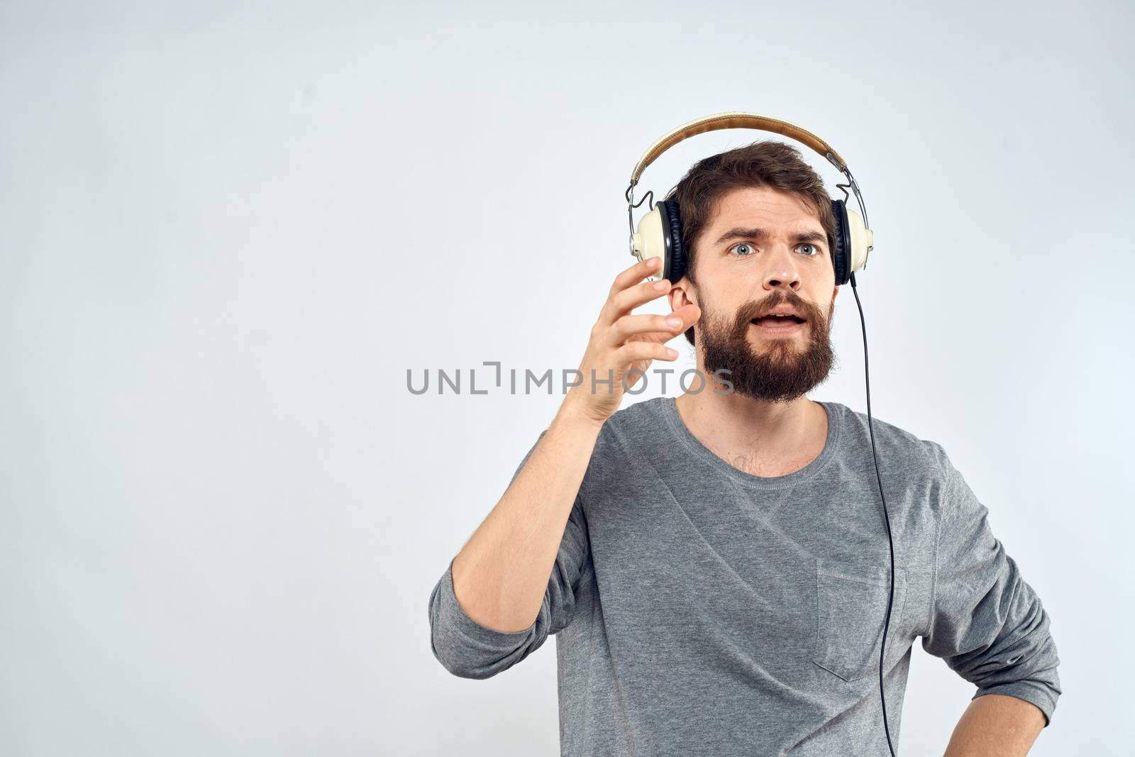 Man in headphones listens to music lifestyle modern style technology light background. High quality photo