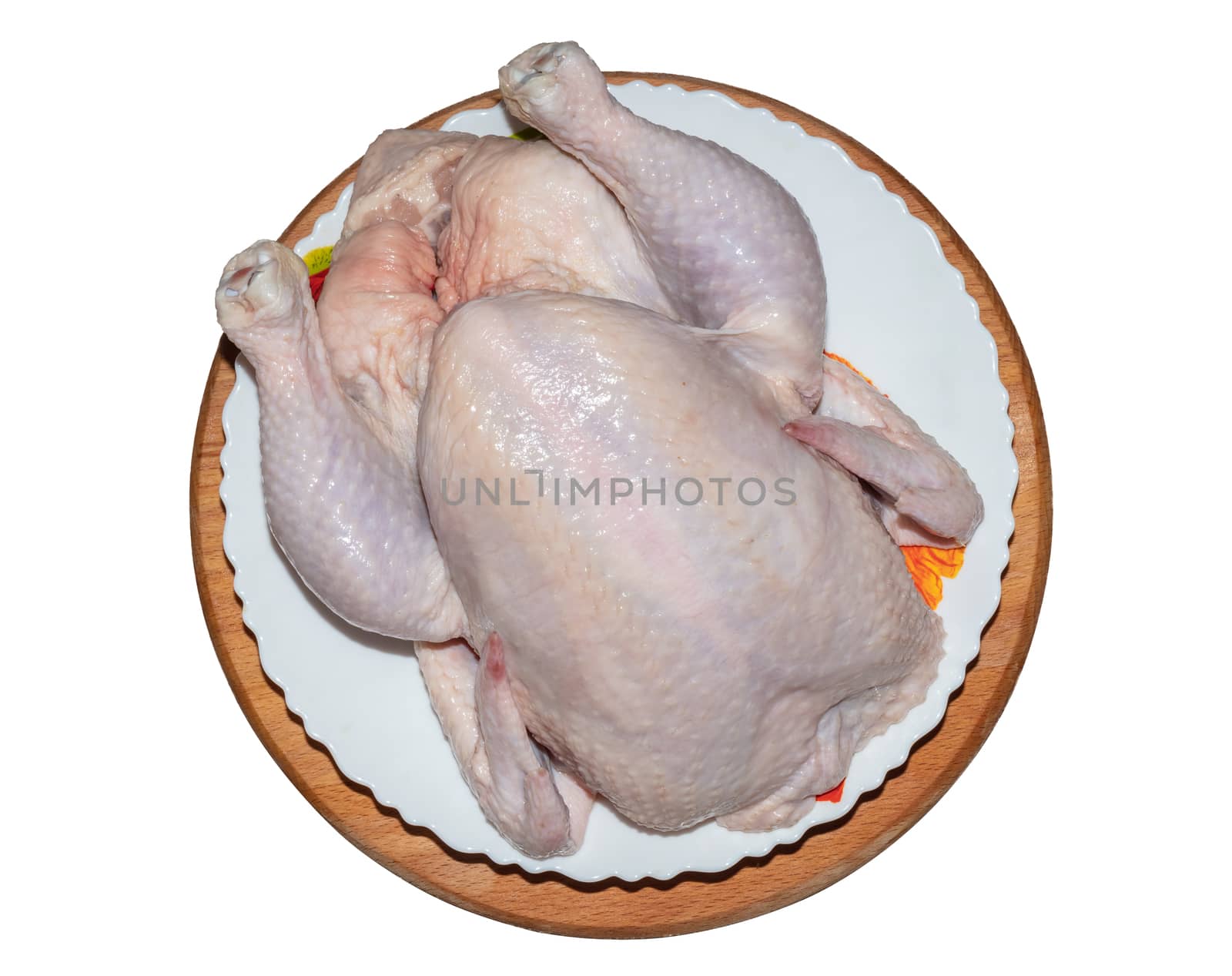 A top close-up shot of a whole chicken on a plate and wooden board. Isolated on white background.