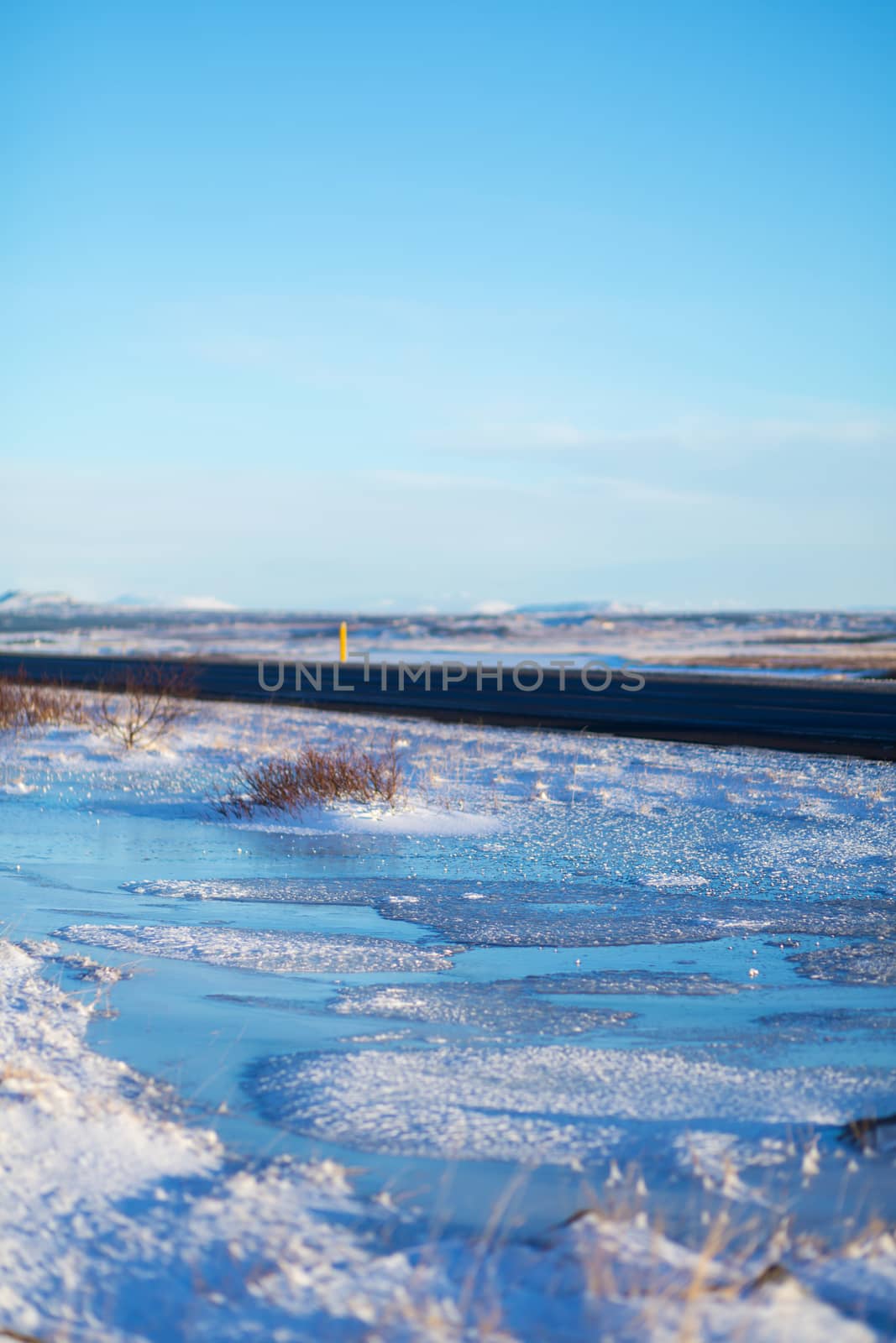 River on the plain in Iceland. The banks are covered with snow. Winter landscape, open spaces