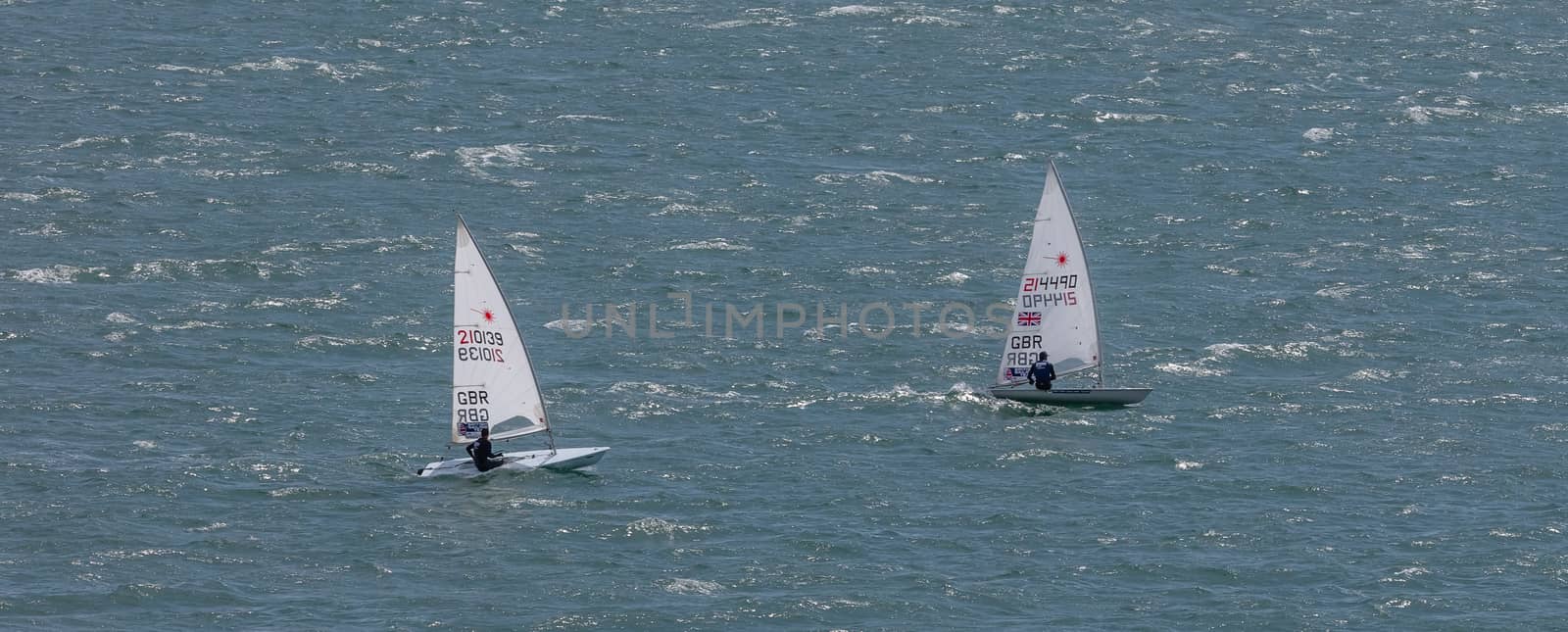 Portland harbour, United Kingdom - July 3, 2020: High Angle aerial panoramic shot of two laser class racing dinghies in Portland harbour.