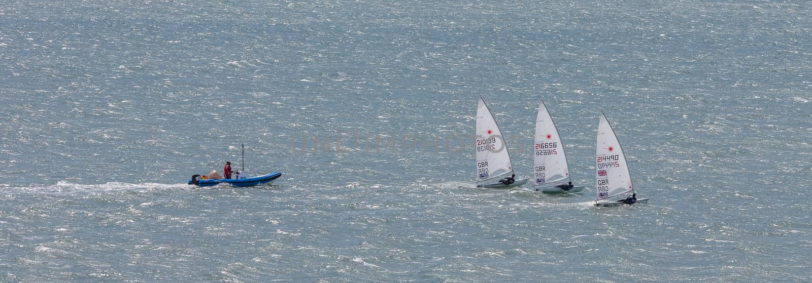 Portland harbour, United Kingdom - July 3, 2020: High Angle aerial panoramic shot of the laser class racing dinghies and a rescue boat in Portland harbour.