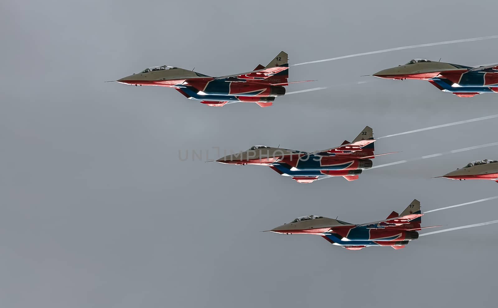 Barnaul, Russia - September 18, 2020: A low angle close-up shot of Strizhi MiG-29 fighter jet squadron performing stunts during an aeroshow.