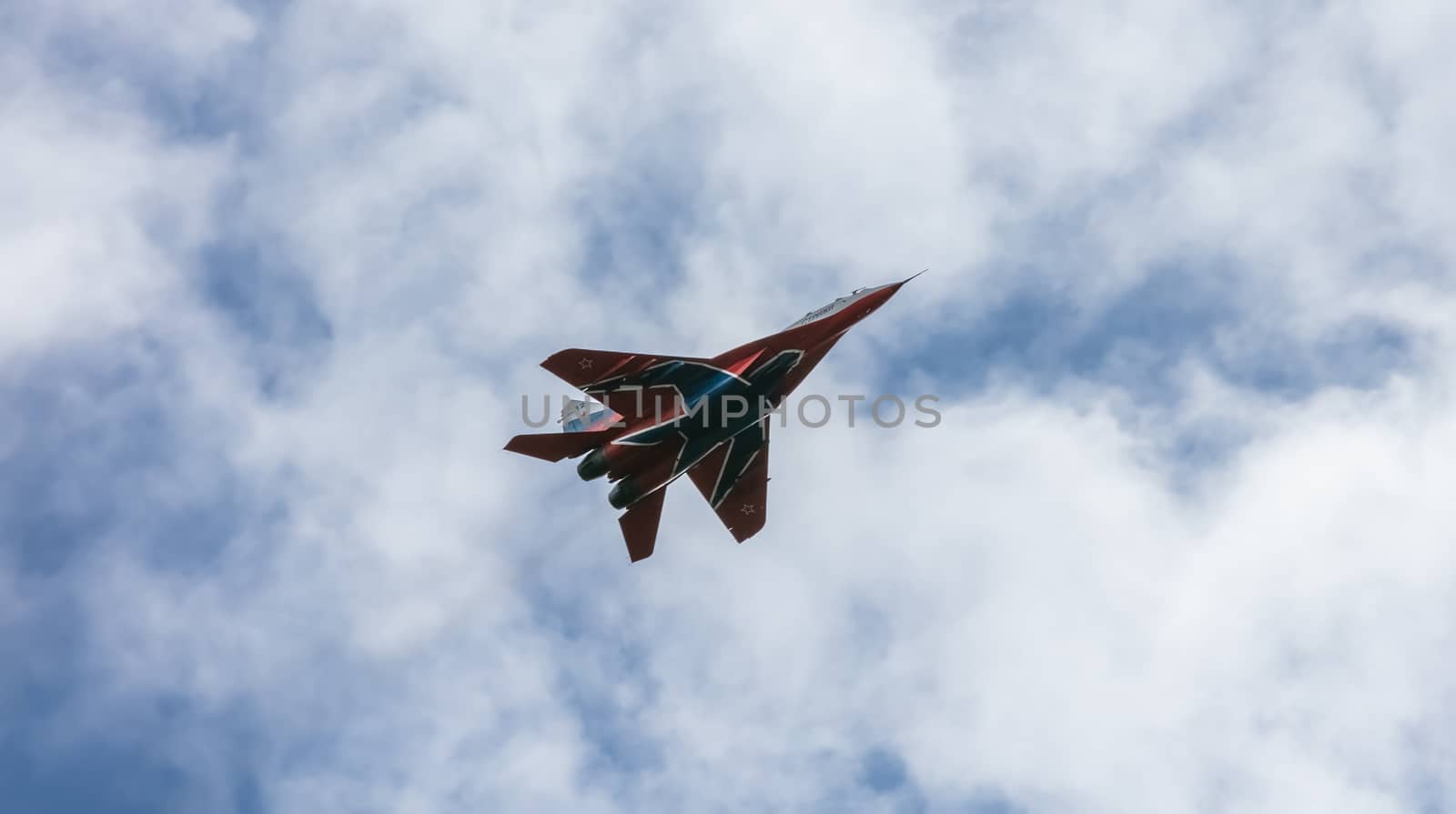 Barnaul, Russia - September 18, 2020: A low angle close-up shot of Strizhi MiG-29 fighter jet performing stunts during an aeroshow. Blue cloudy sky as a background.