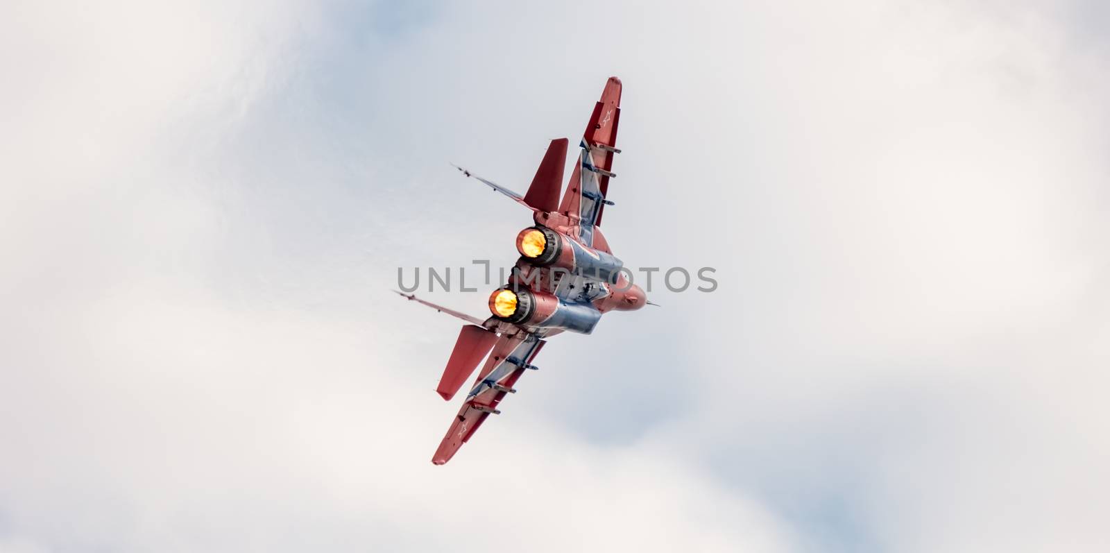 Barnaul, Russia - September 19, 2020: A close-up shot of Strizhi MiG-29 fighter jet performing stunts during an aeroshow. White cloudy sky as a background.