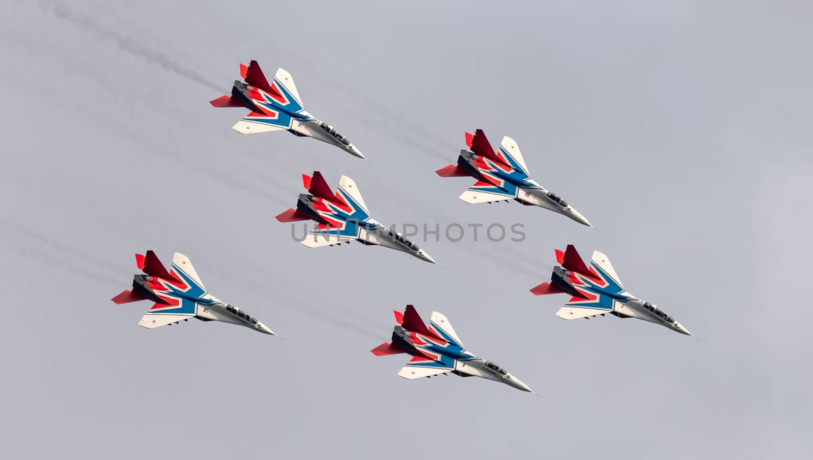 Barnaul, Russia - September 19, 2020: A shot of Strizhi MiG-29 fighter jet squadron performing stunts during an aeroshow. White cloudy sky as a background.