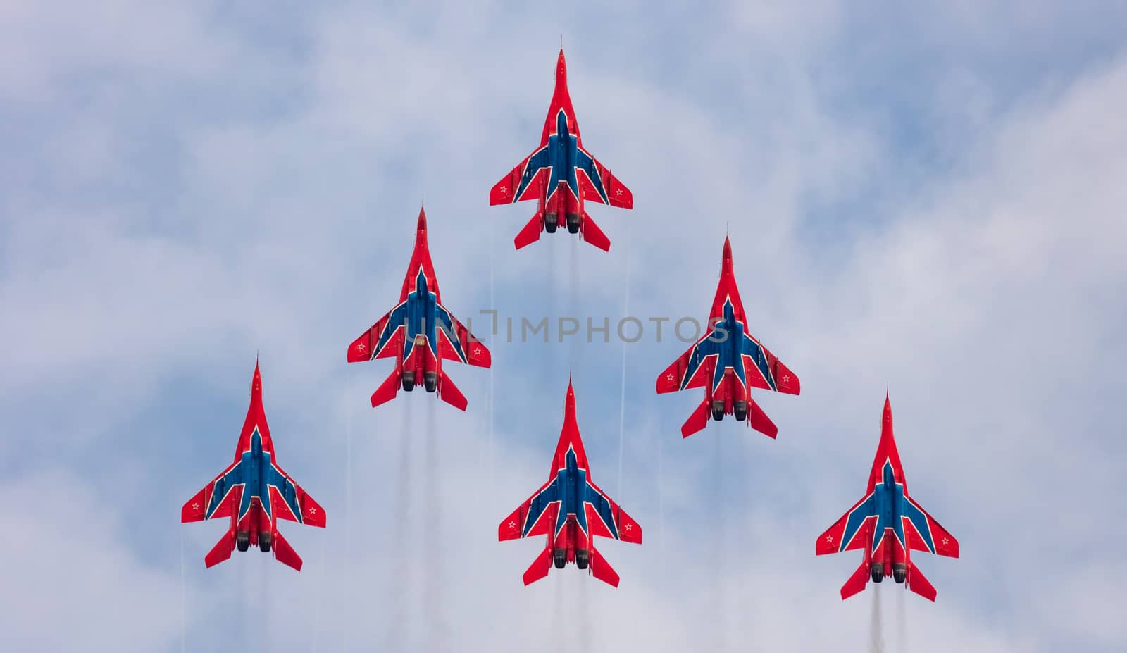 Barnaul, Russia - September 19, 2020: A shot of Strizhi MiG-29 fighter jet squadron performing vertical ascending during an aeroshow. Blue cloudy sky as a background.