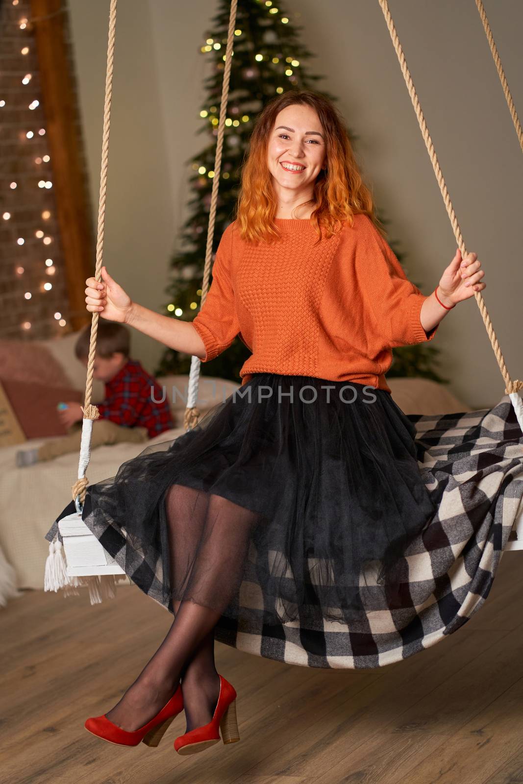 A beautiful redhead girl is swinging in her room on Christmas night.