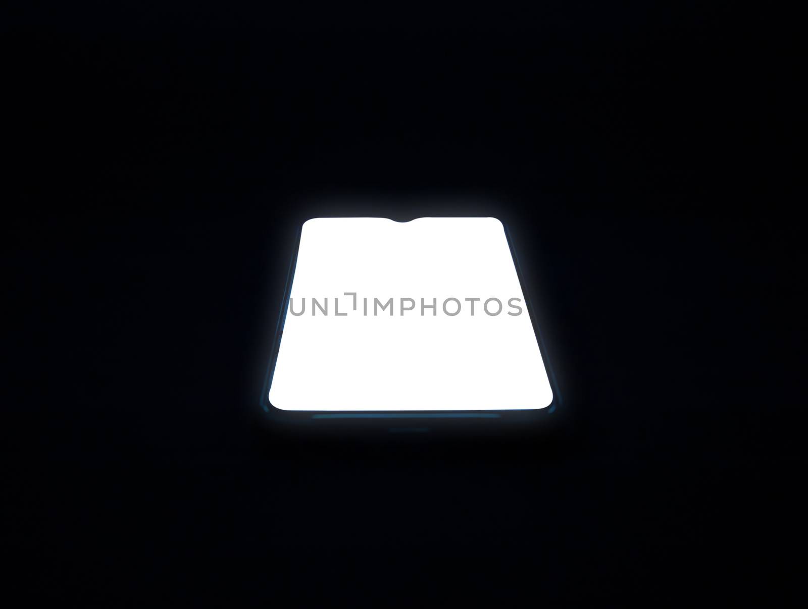 A phone with a blank white screen on a dark black background. by Unimages2527