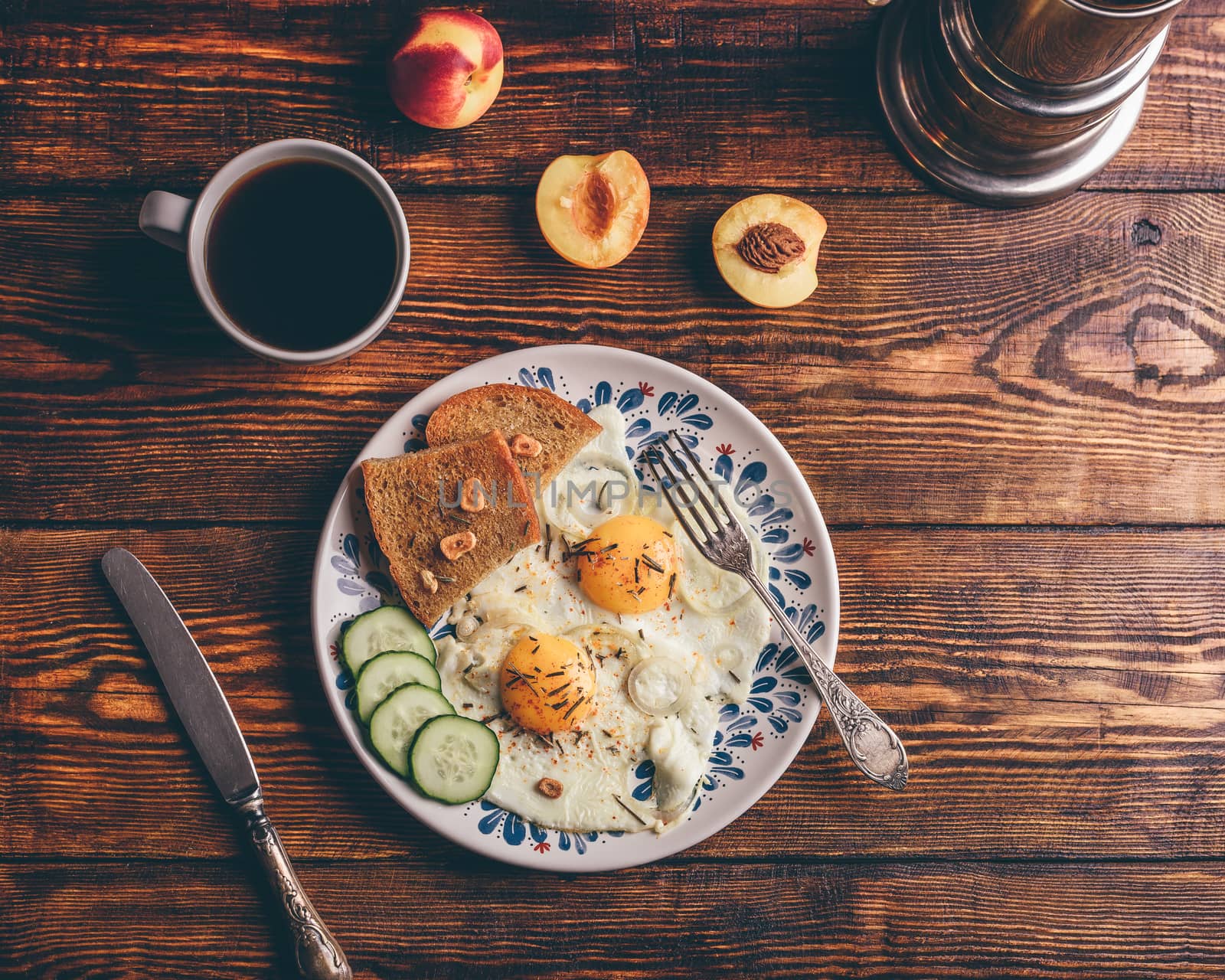 Breakfast toast with fried eggs with vegetables on plate and cup of coffee with fruits over dark wooden background, top view. Healthy food concept.