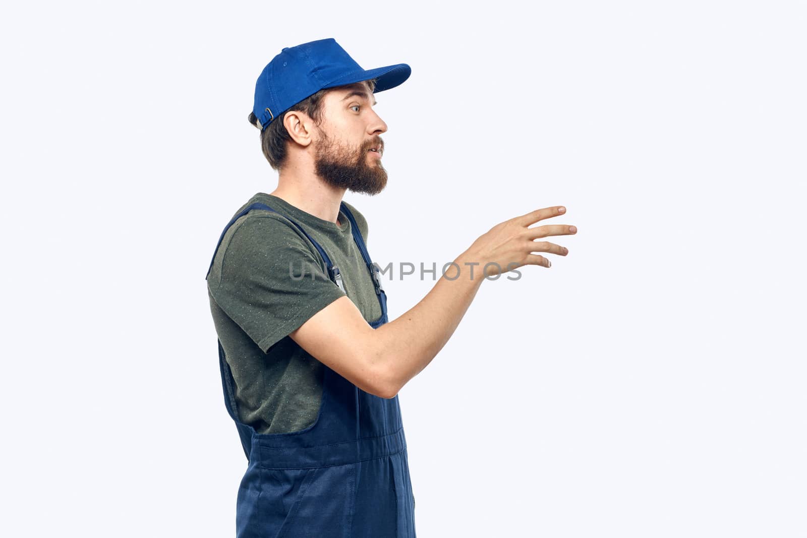 Worker man uniform delivery service emotions studio light background. High quality photo