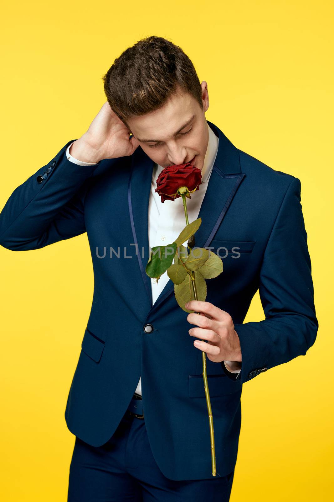 Gentlemen in classic suit on yellow background and red rose romance cropped view model portrait. by SHOTPRIME