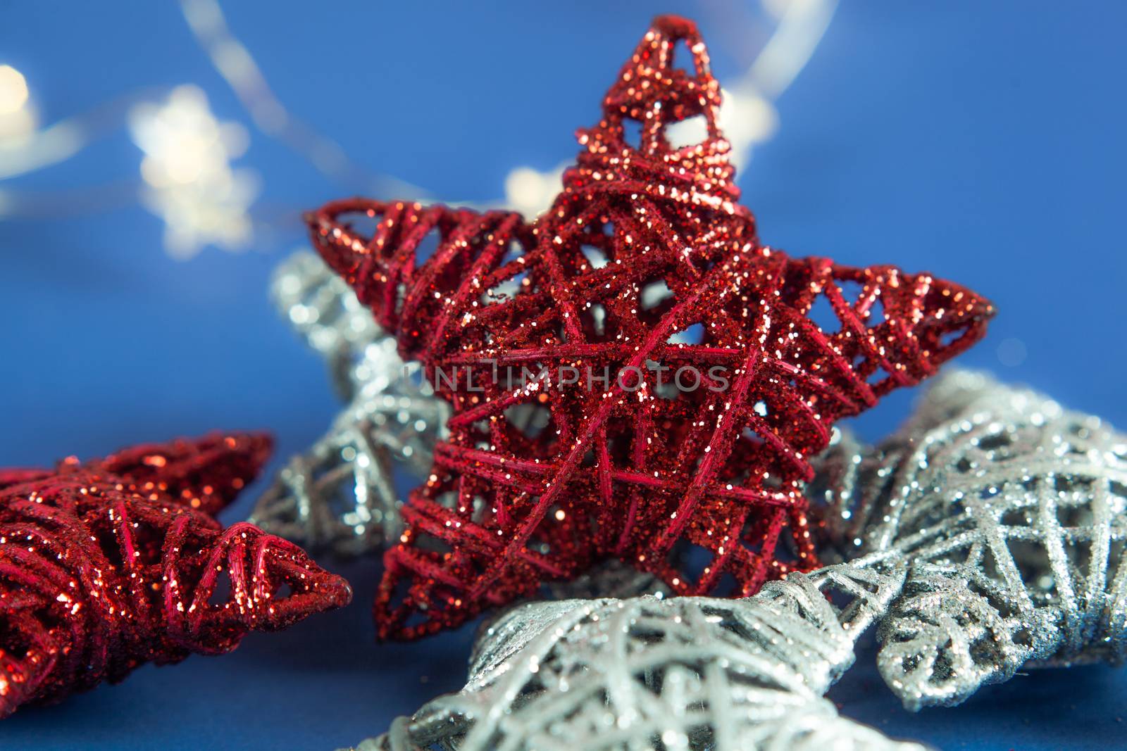 Brilliant red silver Christmas star on blue background. Use for New Year's greetings. Minimal banner, copy space for text, flatlay.