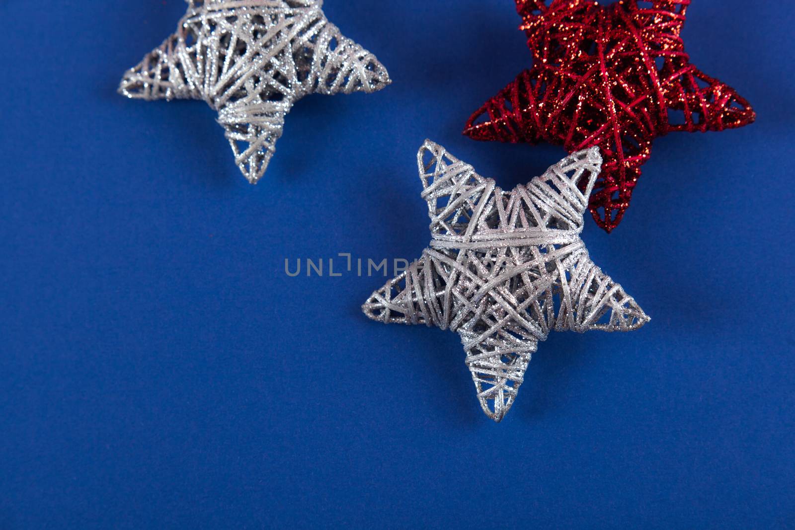 Brilliant red silver Christmas star on blue background. Use for New Year's greetings. Minimal banner, copy space for text, flatlay.