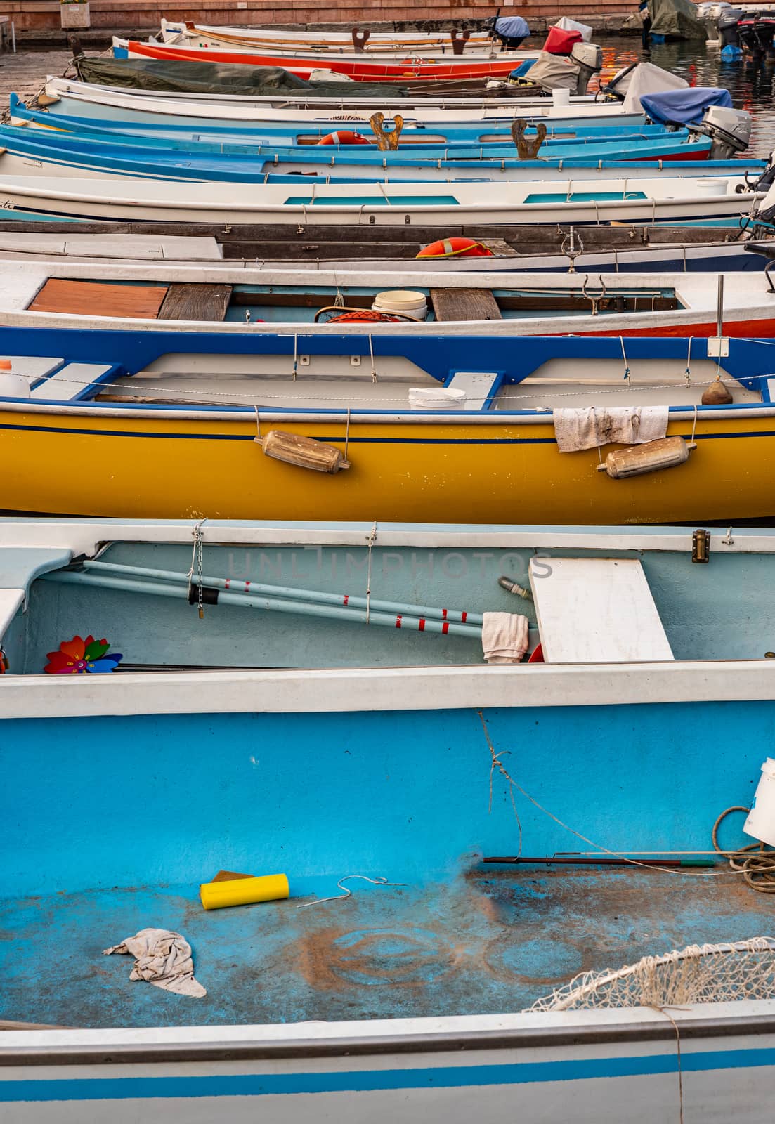 Side view of series of brightly colored boats moored at the harbor, street photography set at the lake