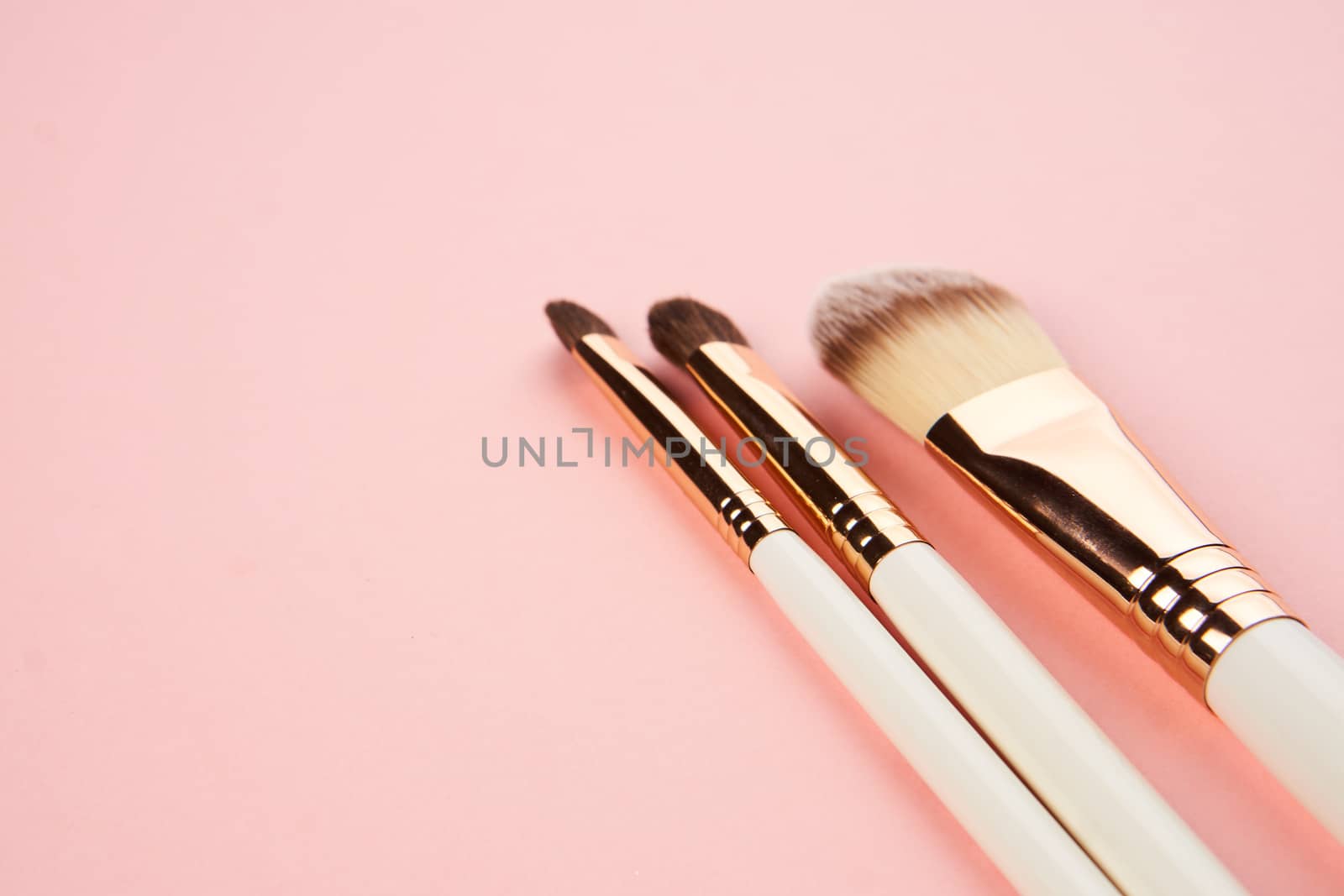 Makeup brushes on a pink background in different sizes cropped view by SHOTPRIME