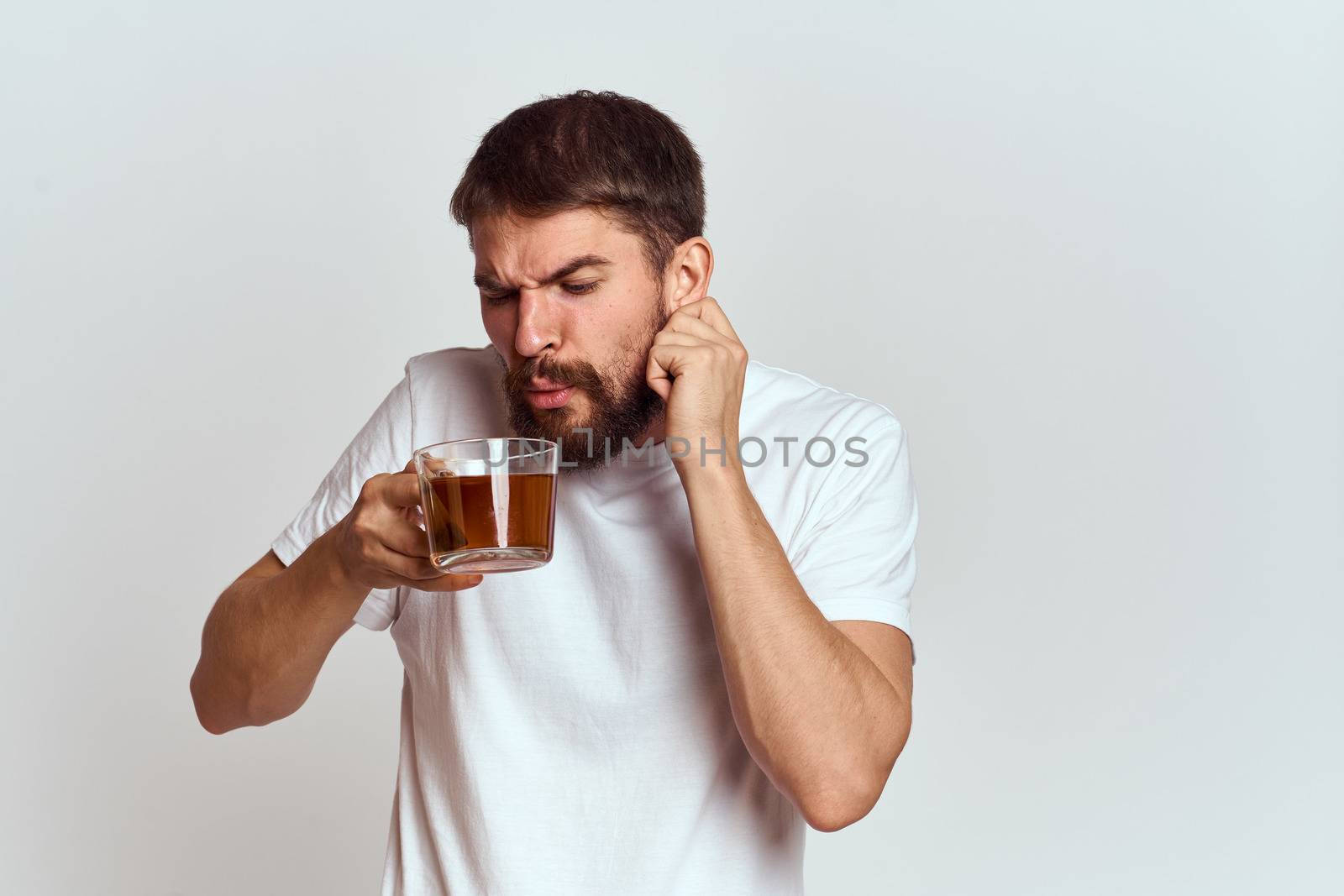 man with a cup of tea in a bag on a light background Hot drink cropped view model. High quality photo