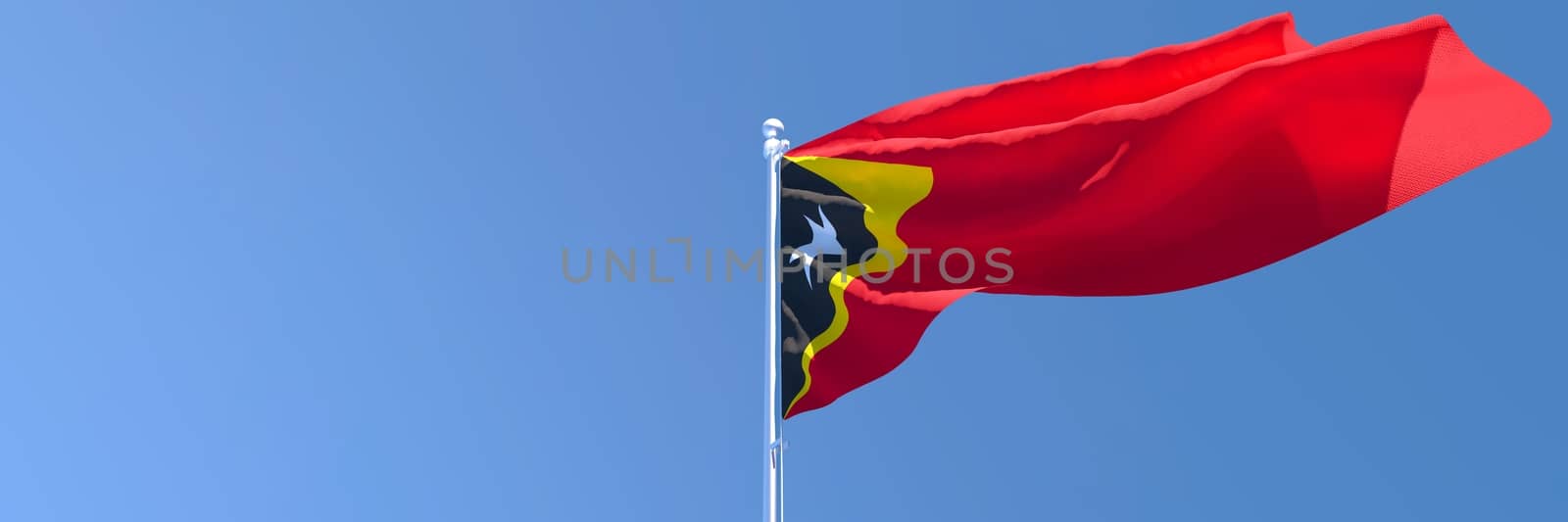 3D rendering of the national flag of East Timor in the wind against a blue sky