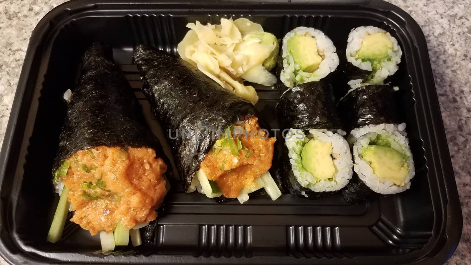 spicy tuna and handroll and avocado sushi in container on counter