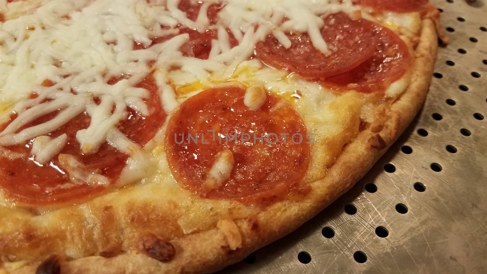 pepperoni pizza with cheese and grease on metal baking tray