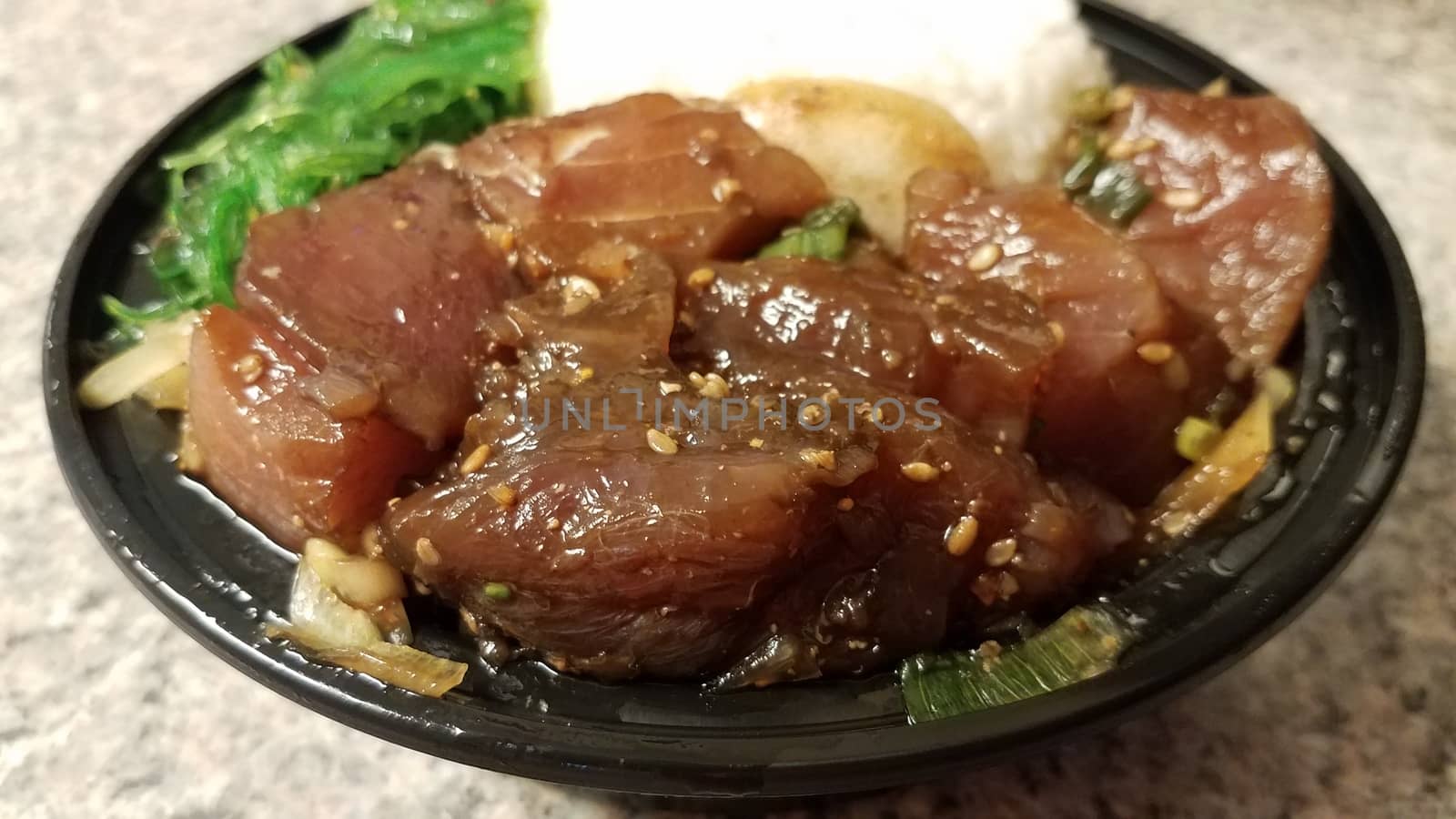 raw tuna and rice and seaweed Hawaiian poke in container on counter