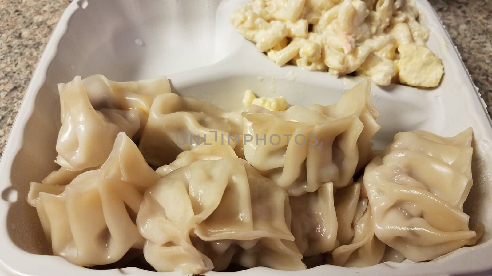 take out container of dumplings and macaroni salad on counter