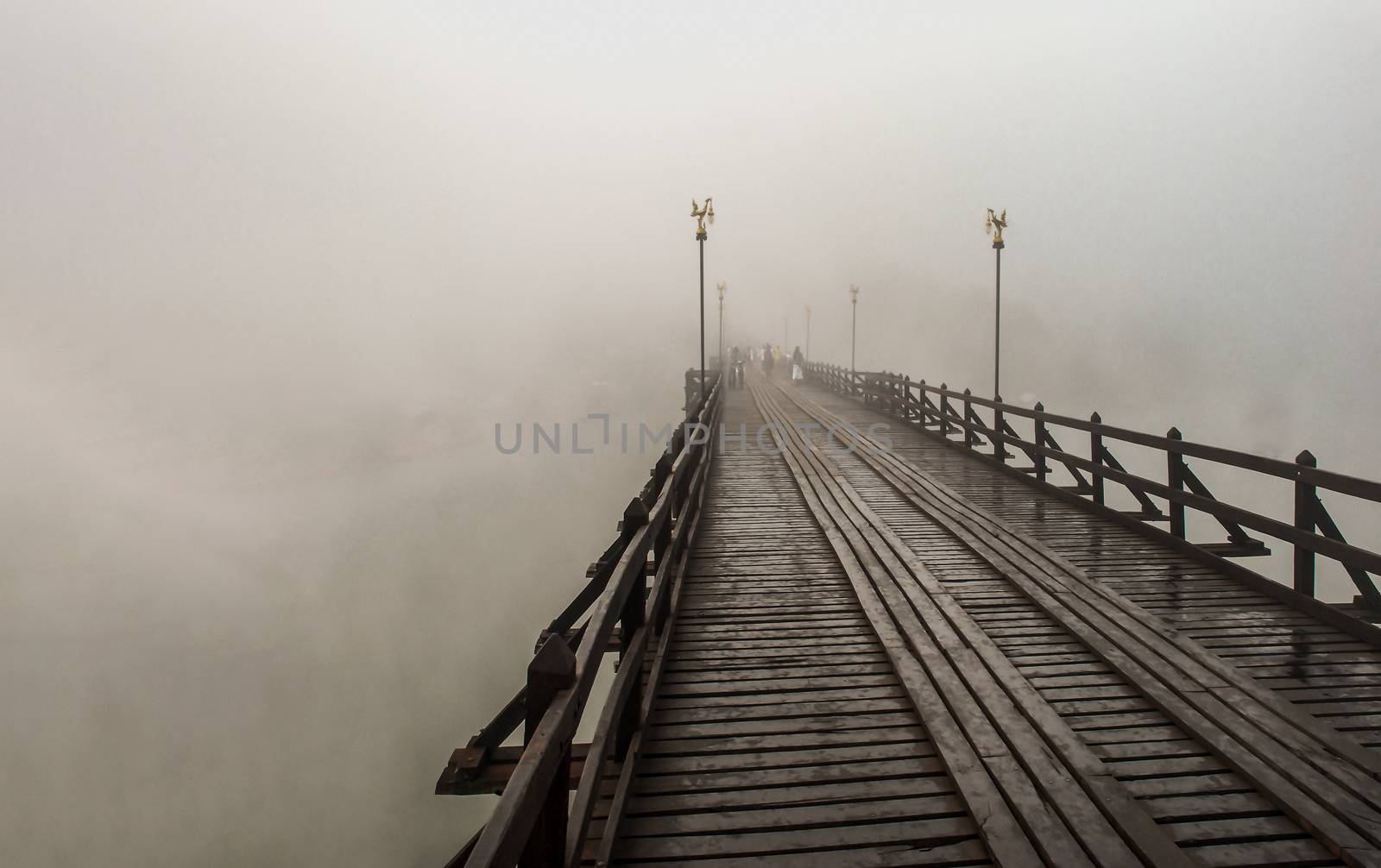 Mon wood bridge in the morning in the fog down (Sangkhla Buri, Kanchanaburi, Thailand) This Mon wood bridge is officially named Uthamanusorn Bridge. No focus, specifically.