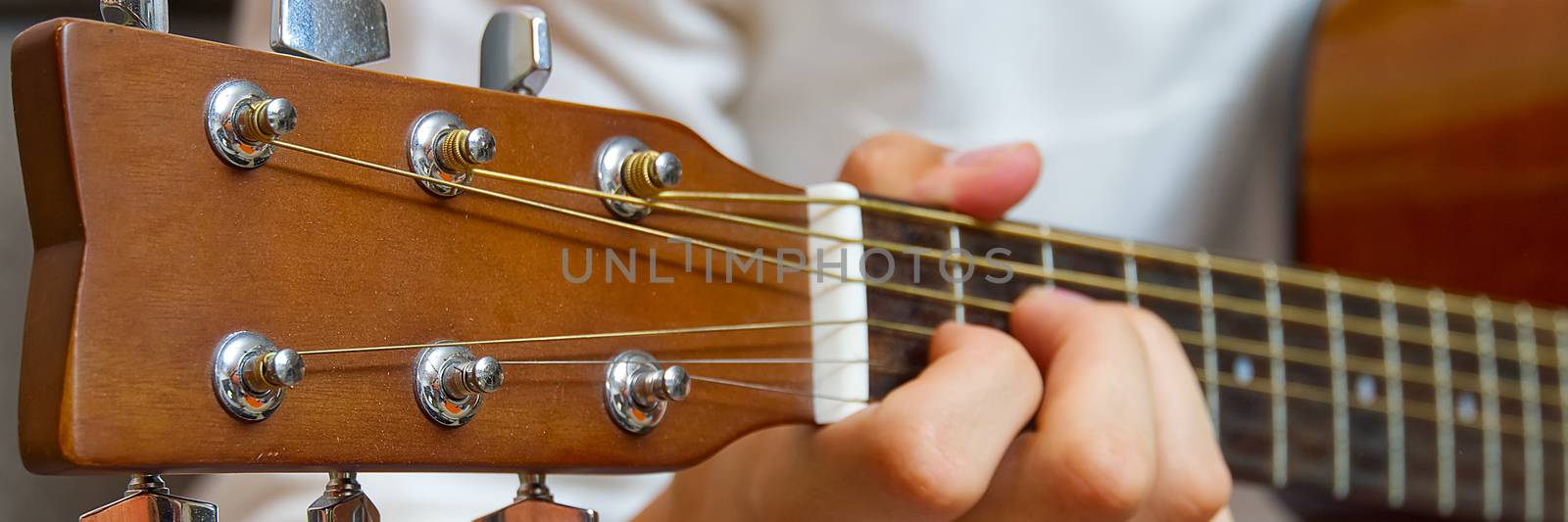 Young boy playing guitar. Close-up of man hand playing classic guitar. teenager learning playing guitar, Banner or panoramic shot.