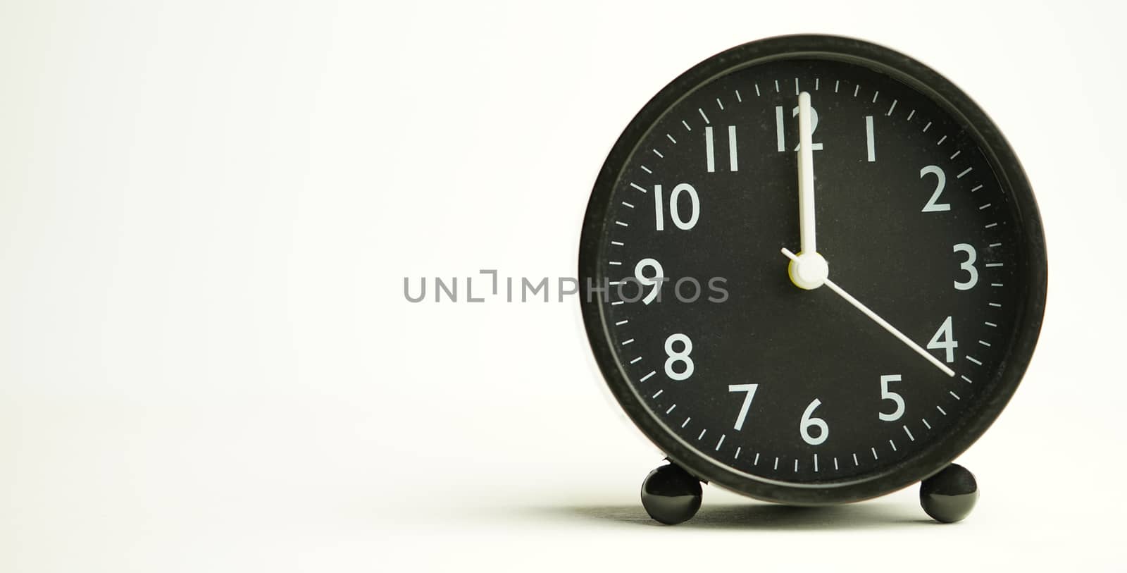 Decorative black alarm clock for noon separating white backgroun by noppha80