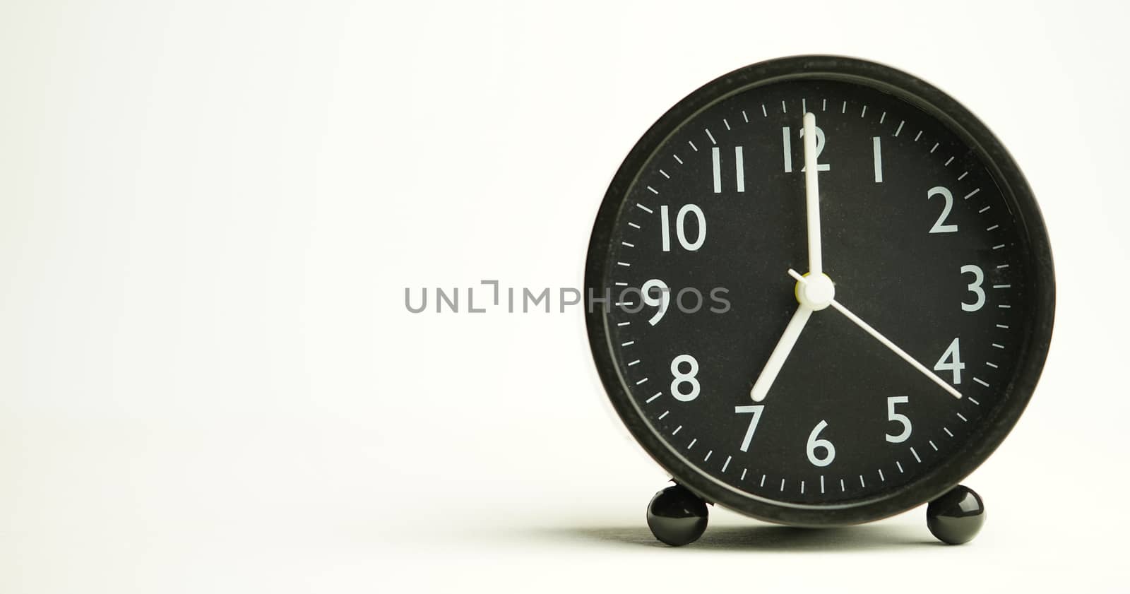 Decorative close-up black alarm clock for 7 hours isolated on wh by noppha80