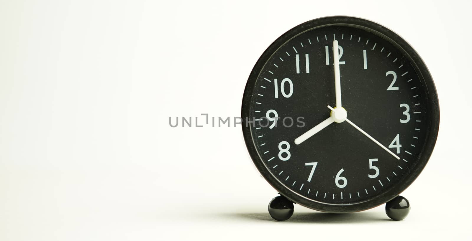 Decorative close-up black alarm clock for 7 hours isolated on white background with abstract copy space, start time of working day.