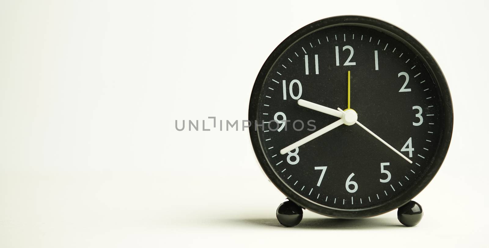 Decorative close-up black alarm clock at 9: 41min, isolated white background with abstract copy space, start time of working day.