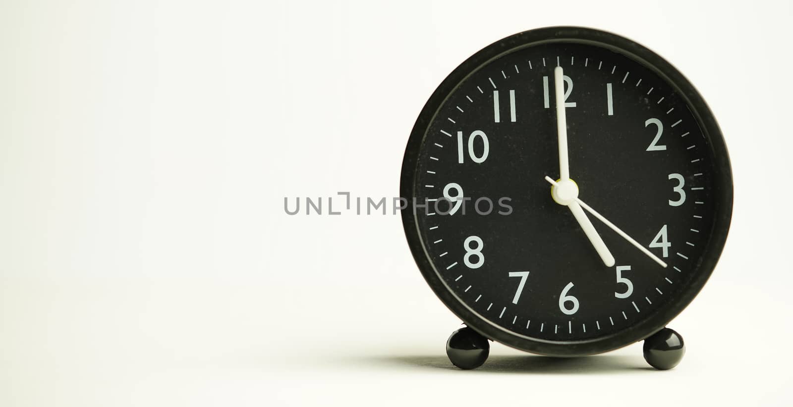Decorative close-up black analog alarm clock for 5 o'clock or 17 by noppha80