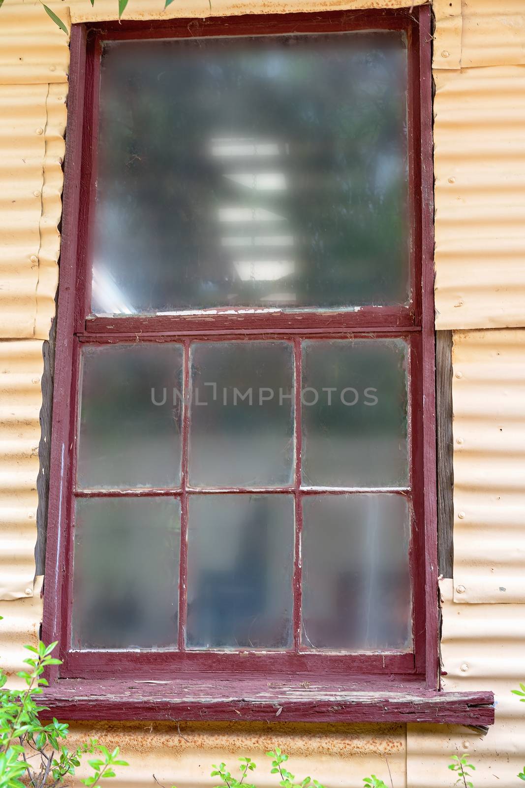 Aging old window with red frames in a disused building
