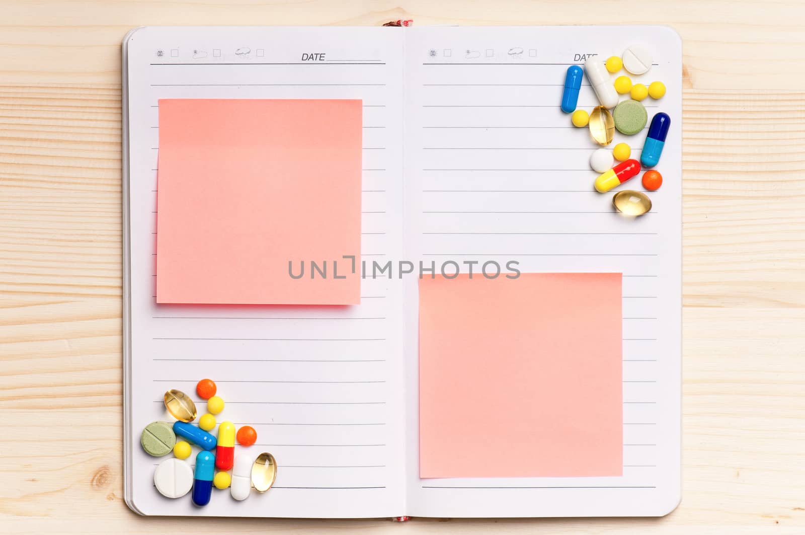 Blank notepad with pills on the wooden table. View from above