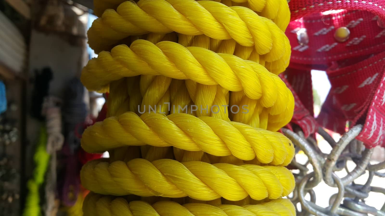 Closeup of bright color braided plastic ropes. Hanks or coil of bright colored plastic rope interwoven which are used for climbing and tightening materials.