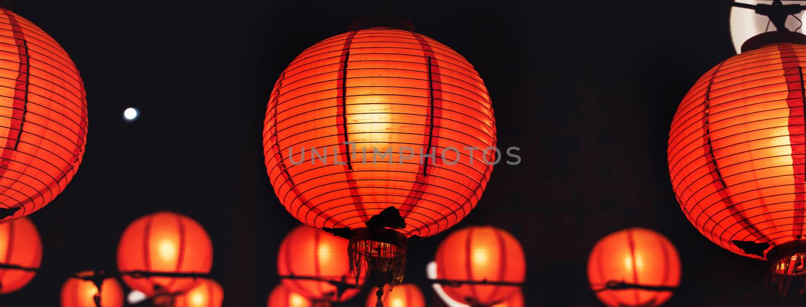 Beautiful round red lantern hanging on old traditional street, c by ROMIXIMAGE