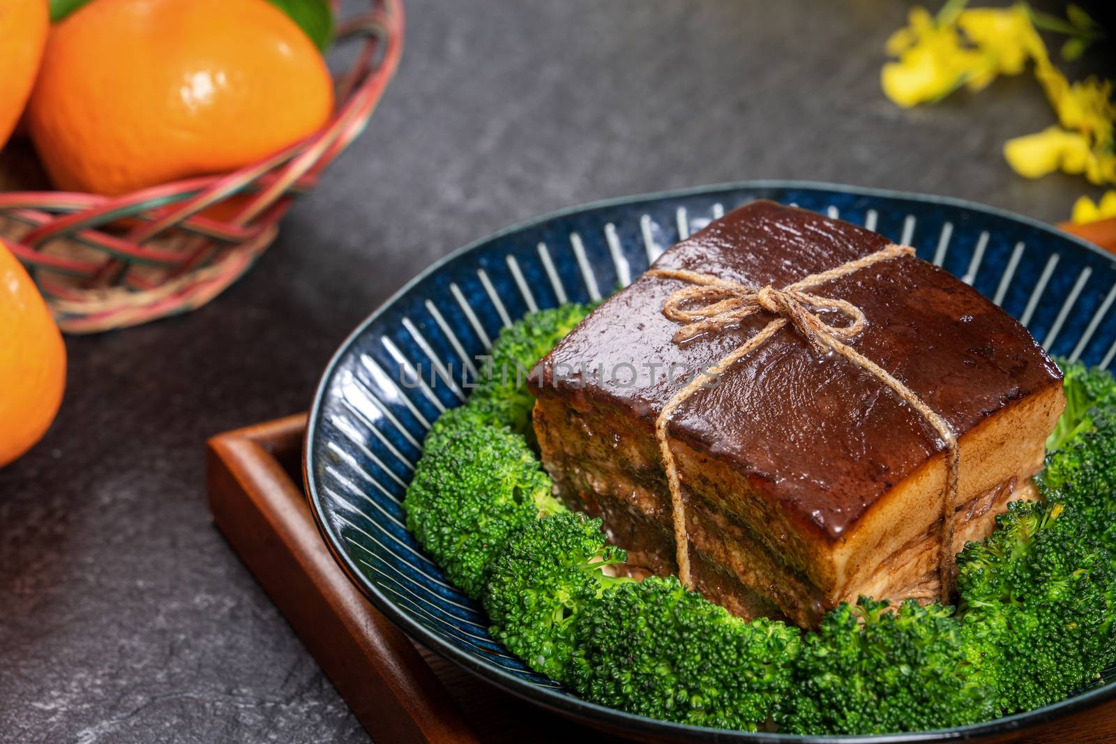 Dong Po Rou (Dongpo pork meat) in a beautiful plate with green broccoli vegetable, traditional festive food for Chinese new year cuisine meal, close up.