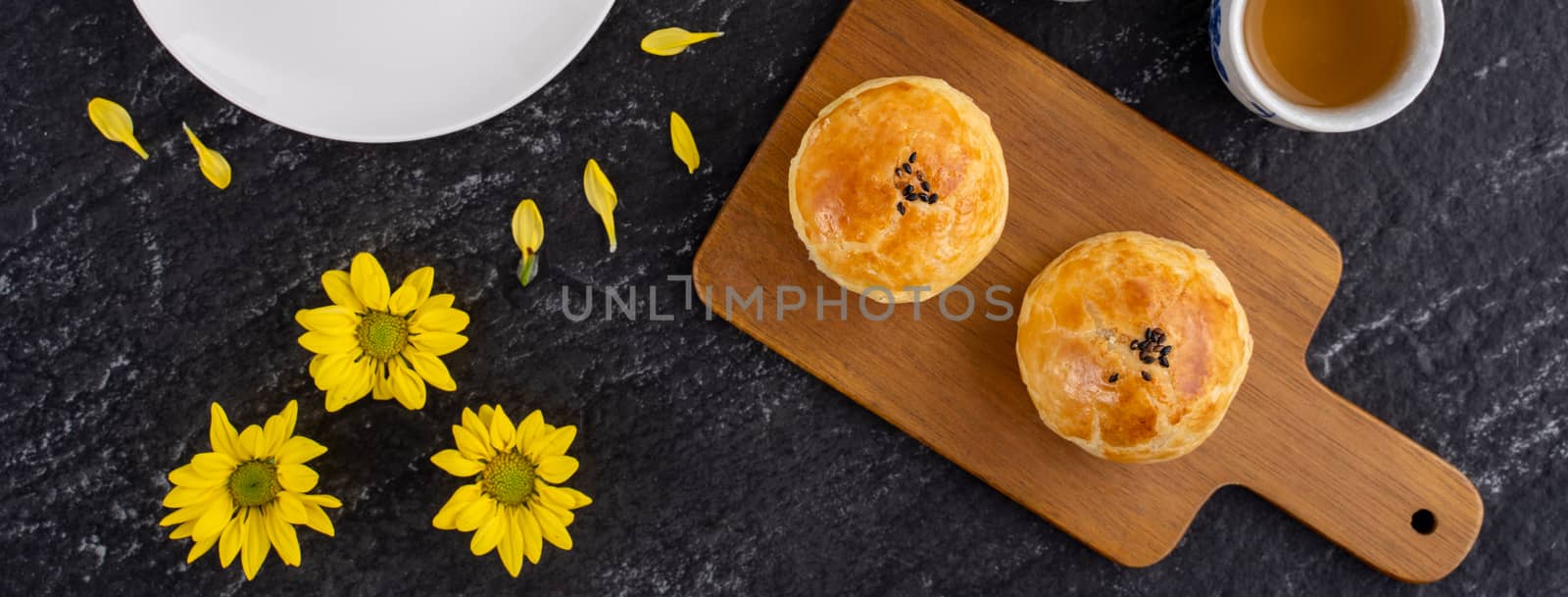 Moon cake yolk pastry, mooncake for Mid-Autumn Festival holiday, top view design concept on dark wooden table with copy space, flat lay, overhead shot