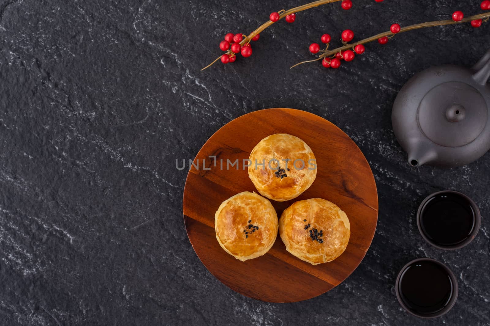 Moon cake yolk pastry, mooncake for Mid-Autumn Festival holiday, top view design concept on dark wooden table with copy space, flat lay, overhead shot