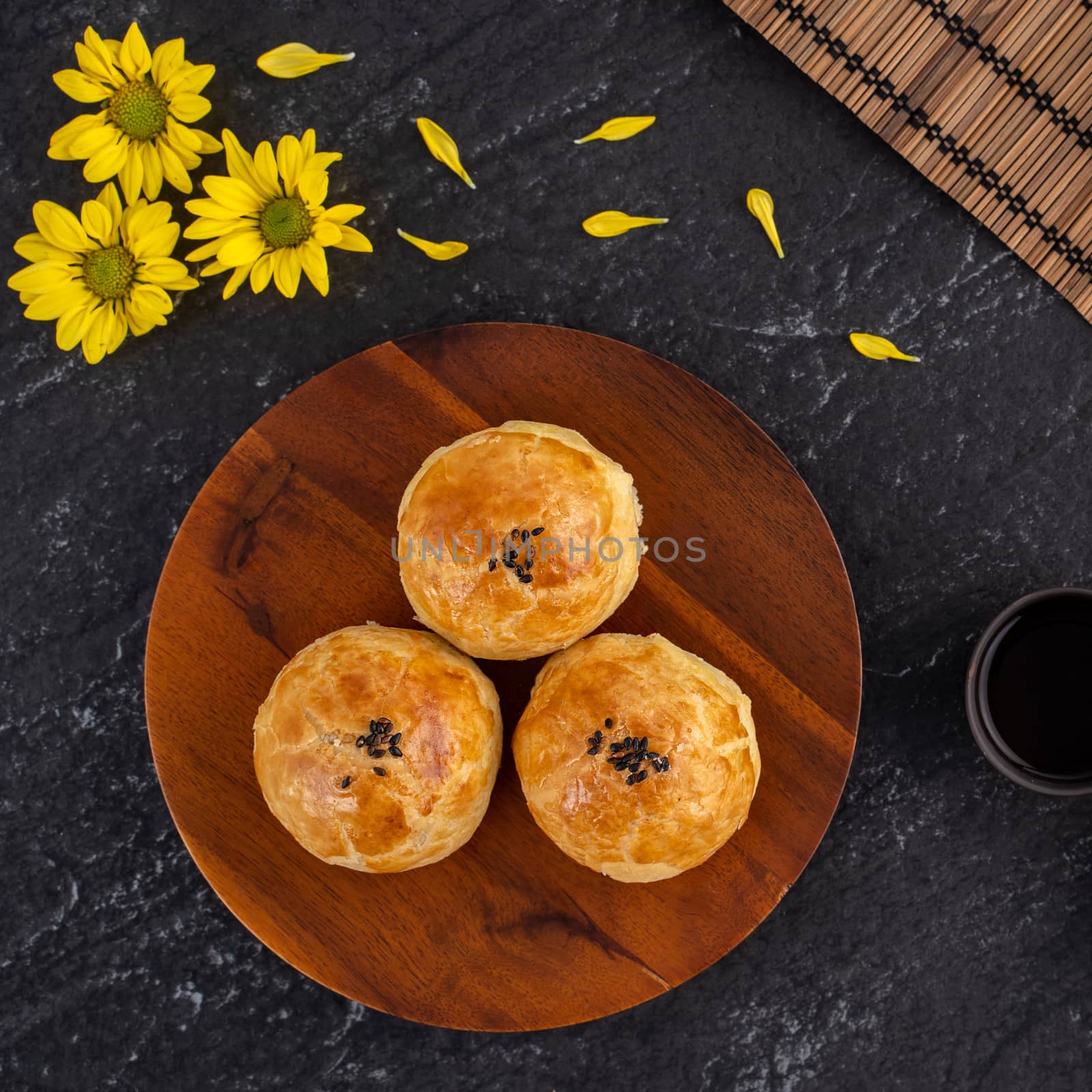 Moon cake yolk pastry, mooncake for Mid-Autumn Festival holiday, top view design concept on dark wooden table with copy space, flat lay, overhead shot