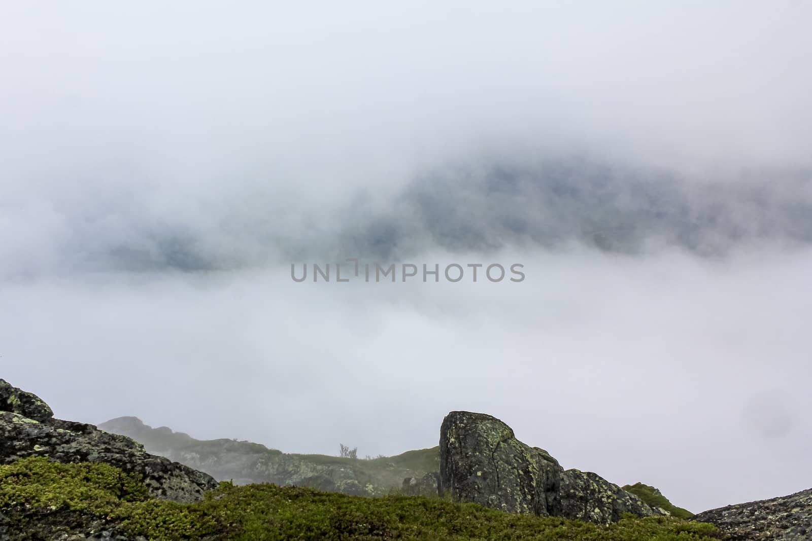 Fog, clouds, rocks and cliffs on Veslehødn Veslehorn mountain in Hemsedal, Norway.