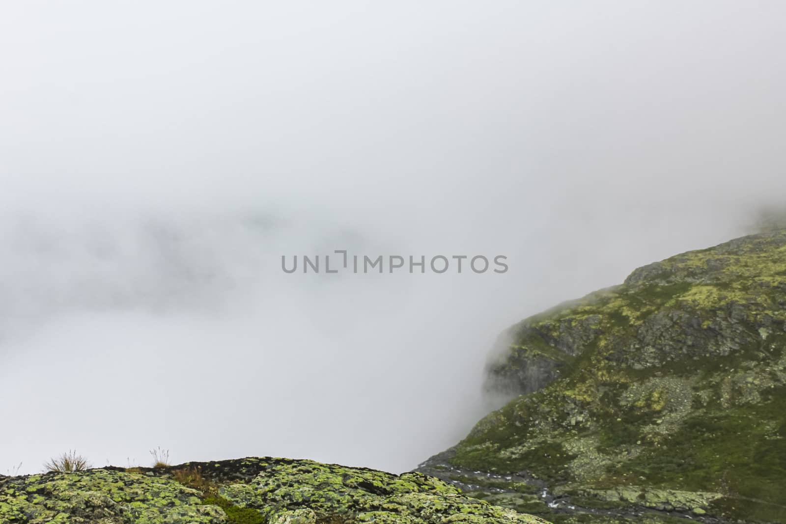 Fog, clouds, rocks and cliffs on Veslehødn Veslehorn mountain in Hemsedal, Norway.