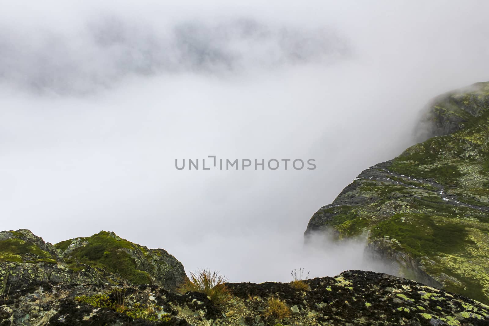 Fog, clouds, rocks and cliffs on Veslehødn Veslehorn mountain in Hemsedal, Norway.