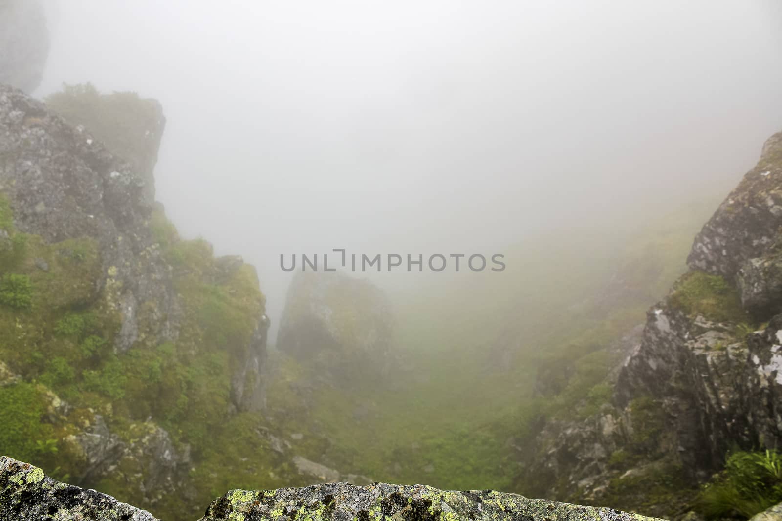 Fog, clouds, rocks and cliffs on Veslehødn Veslehorn mountain in Hemsedal, Norway.