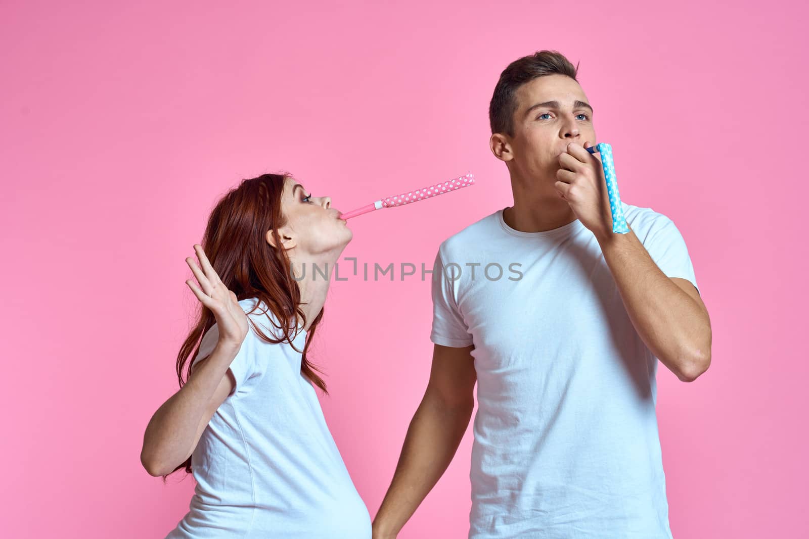 pregnant mom and happy father on pink background Young family waiting for baby by SHOTPRIME