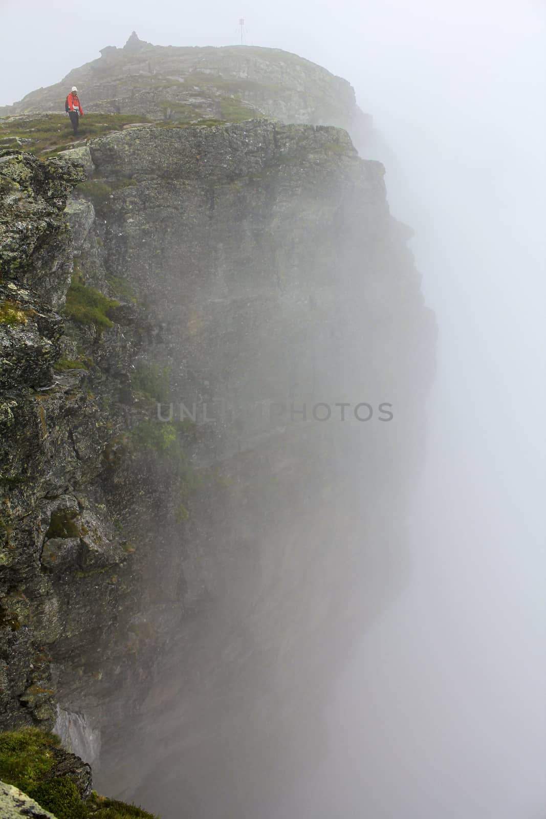 Fog, clouds, rocks and cliffs on Veslehødn Veslehorn mountain, Norway. by Arkadij