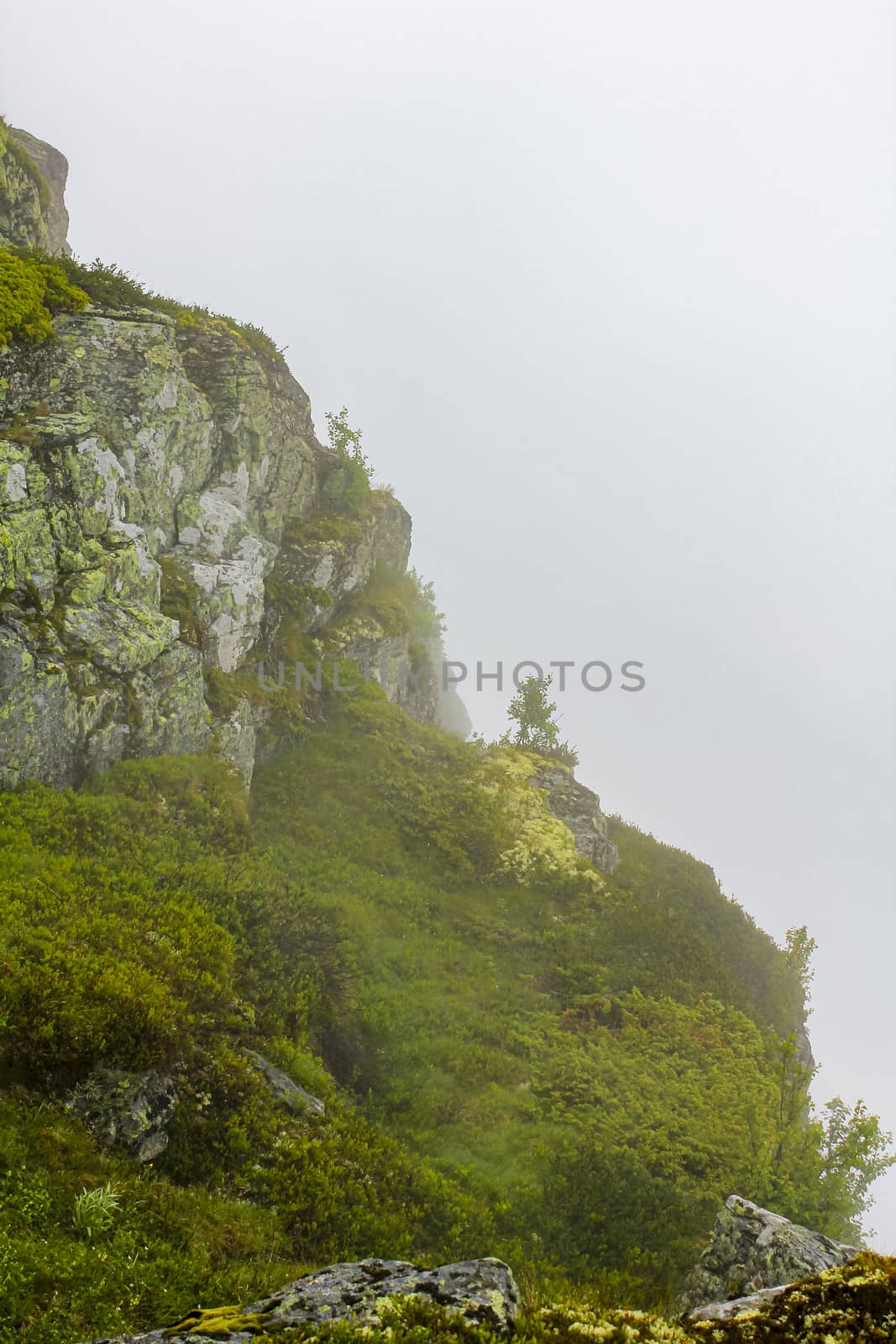 Fog, clouds, rocks and cliffs on Veslehødn Veslehorn mountain in Hemsedal, Norway.