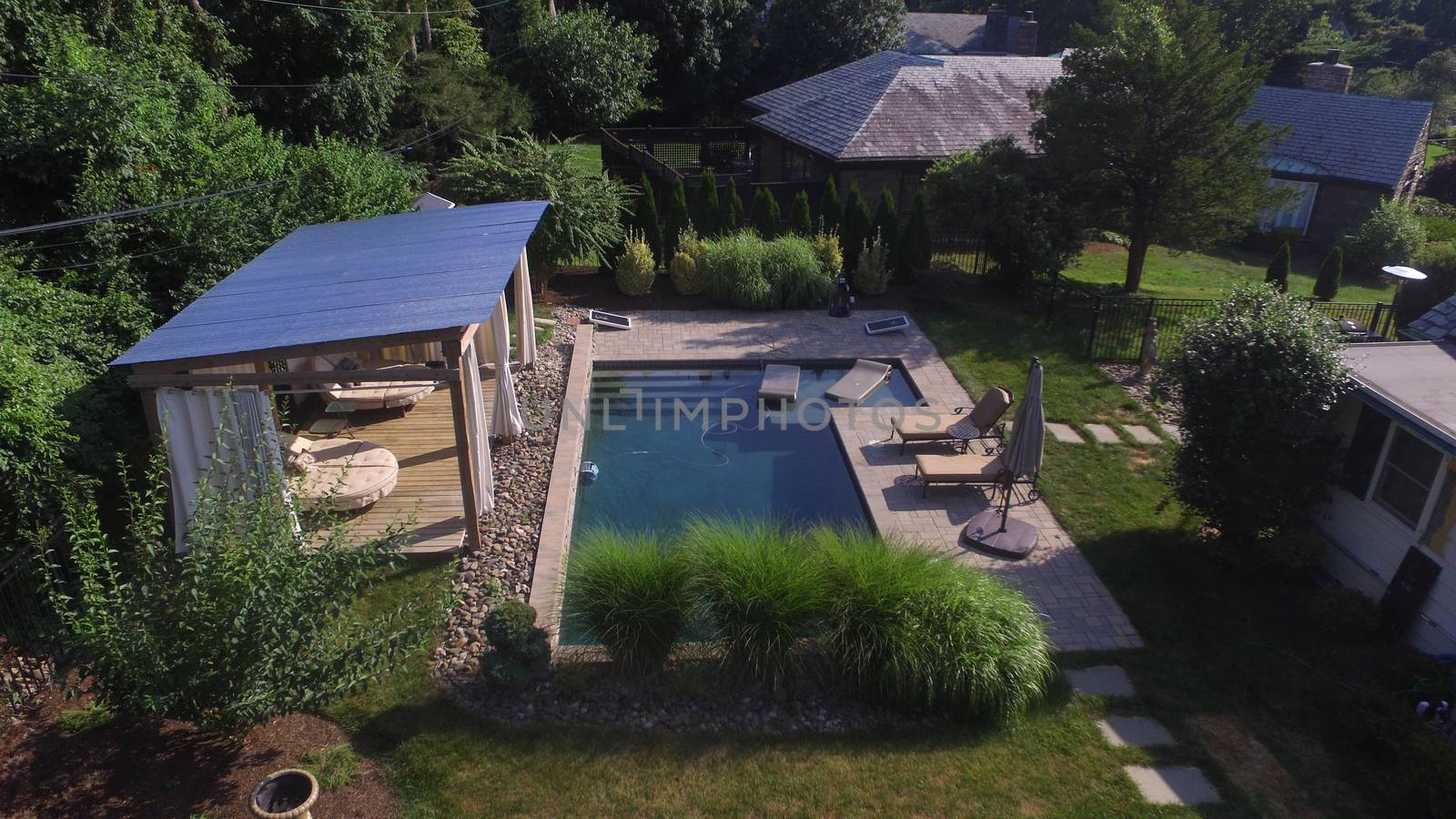 An Overhead Drone Shot of a Gorgeous Suburban Backyard With a Large In-Ground Pool and Cabana