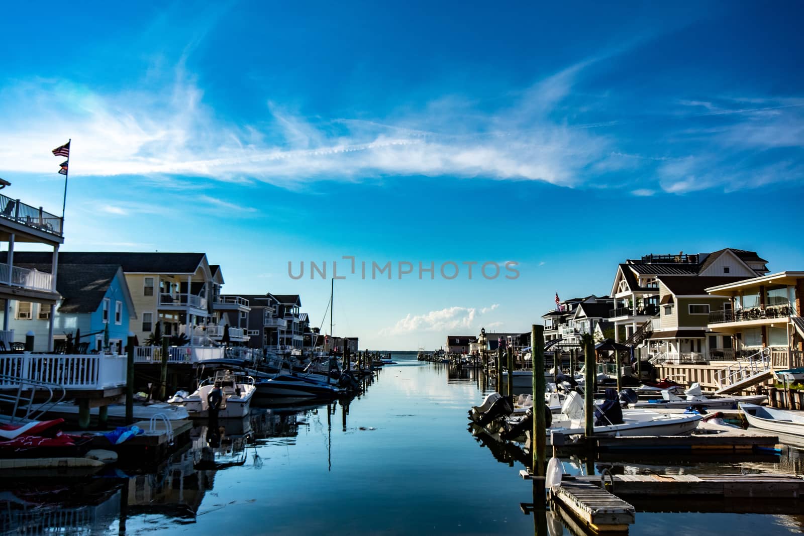 A View of a Canal With Boats and Homes on Each Side on a Clear Blue Sky With Gorgeous Clouds in Wildwood New Jersey