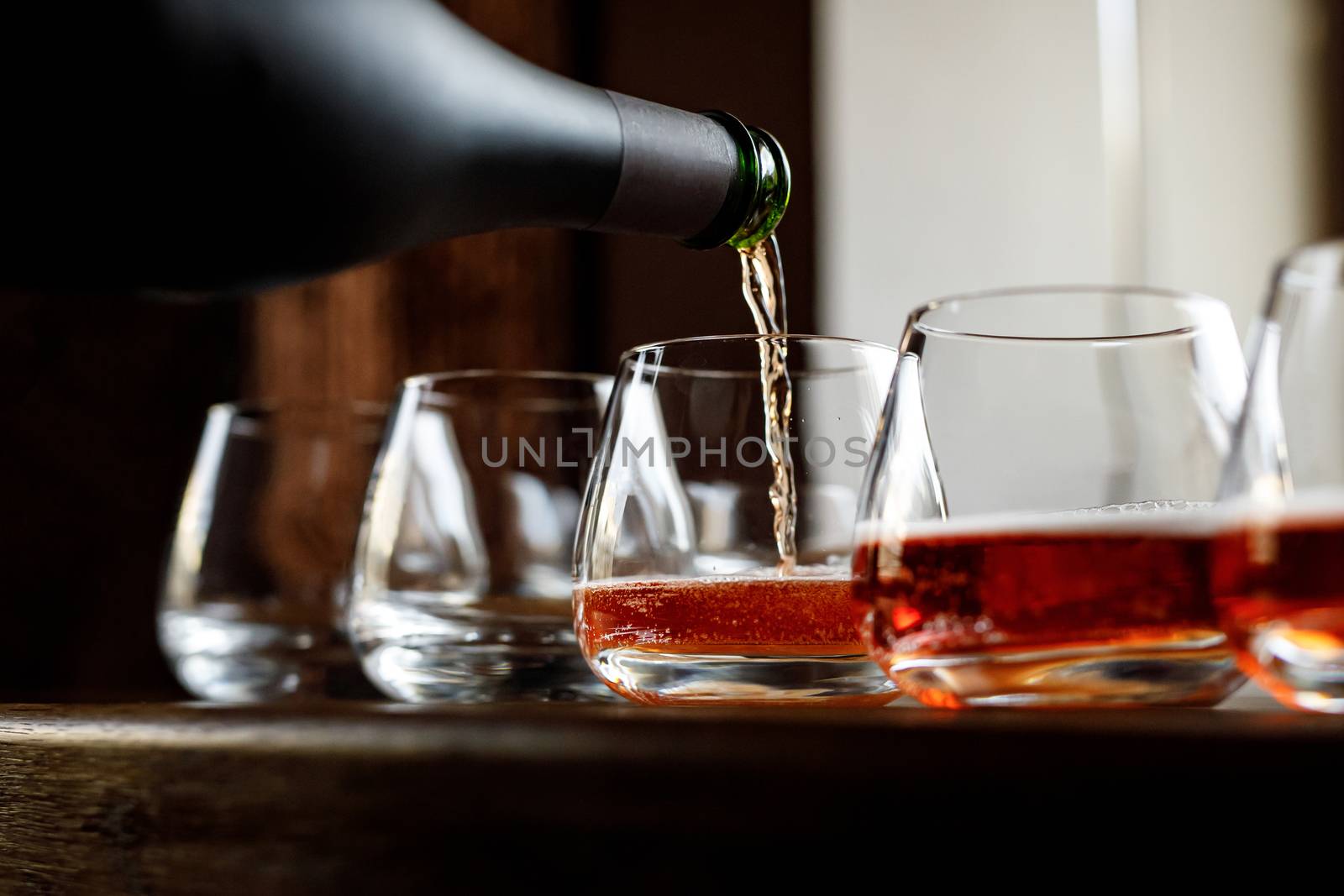 Waiter pouring wine into wineglass. Sommelier pours alcoholic drink. by 9parusnikov